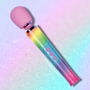 Le Wand All That Glimmers Petite Vibrating Wand with Rainbow Ombre Design and Pink Silicone Head on a rainbow ombre pastel background